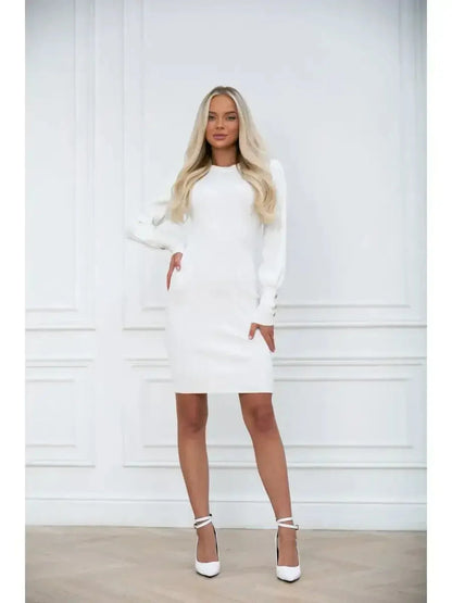 Model showcasing the Ivory Curve dress, a fitted white mini dress with long voluminous sleeves and structured cuffs.
