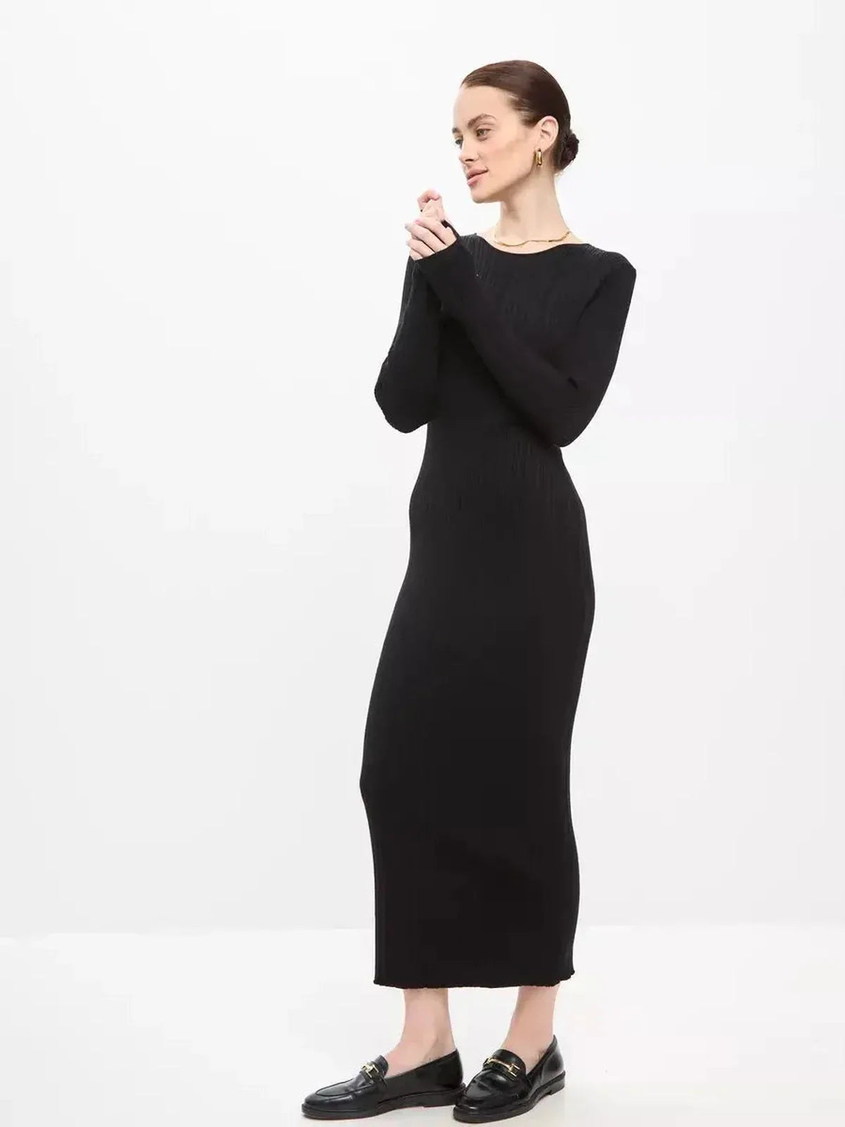 Model wearing a Sculpted Rib Maxi Dress in black, showcasing a streamlined silhouette and elegant design with long sleeves.