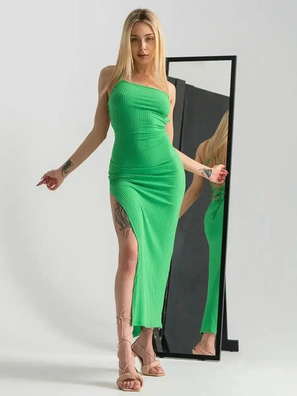 Model showcases the sleek Fit Maxi Dress Emerald Whisper in vibrant green, featuring a strappy back and dramatic leg slit.