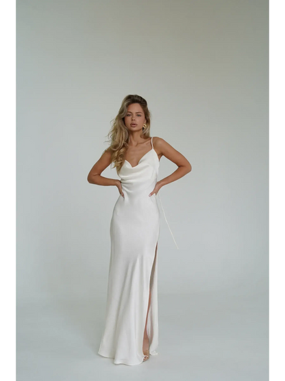 Model wearing an Ivory Luxe Maxi Dress featuring a cowl neckline and high side slit, exuding elegance.