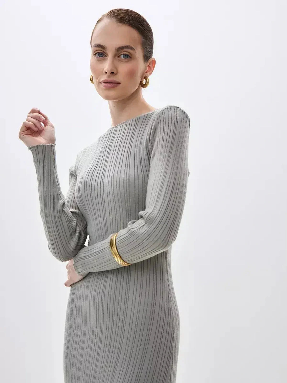Model showcasing the Sculpted Grace Maxi Dress in soft ribbed knit, highlighting its minimalist elegance and sculptural fit.