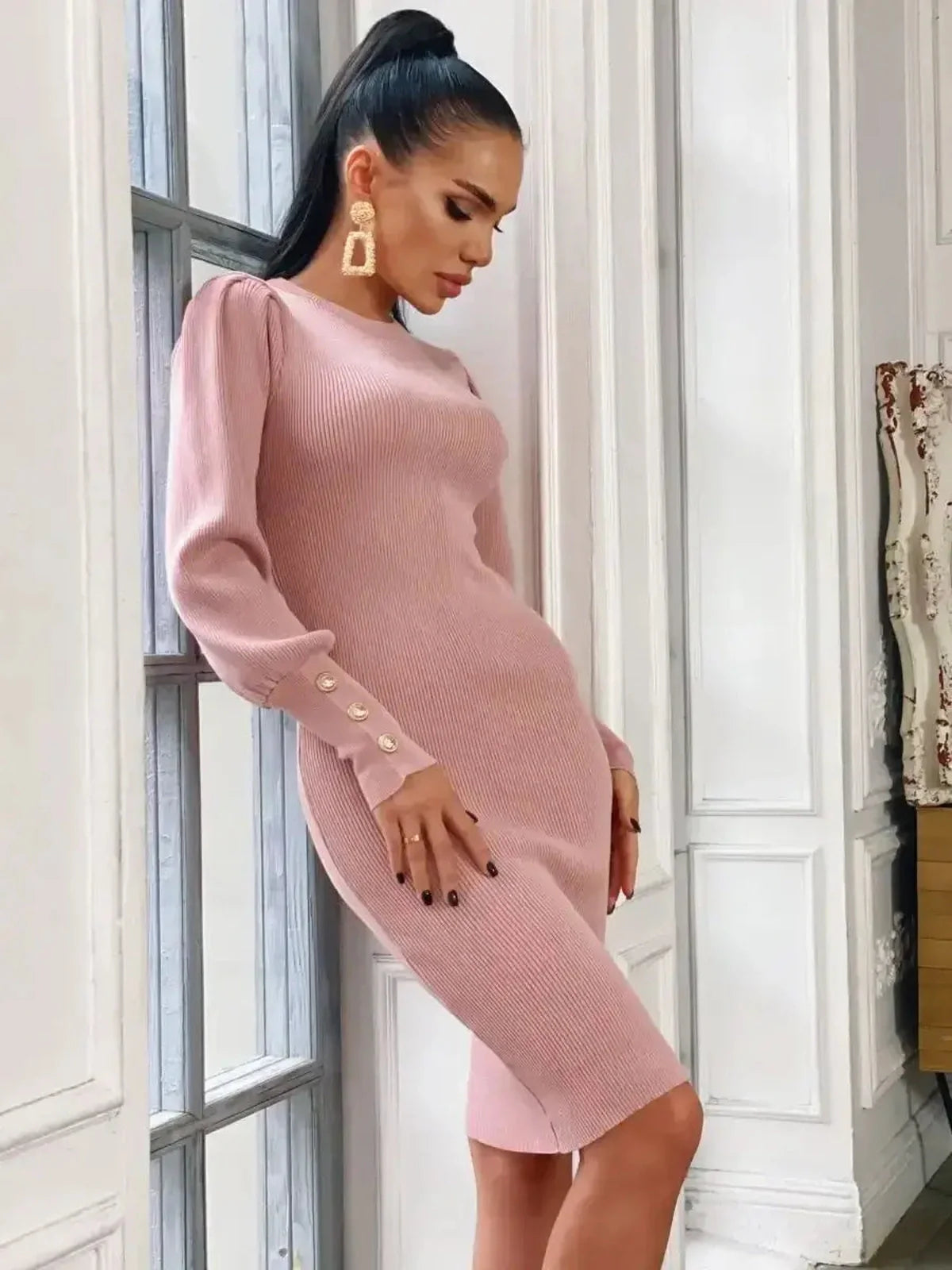 Model showcases the Blush Hour mini dress in soft pink, featuring puff sleeves and gold-tone buttons for elegant style.