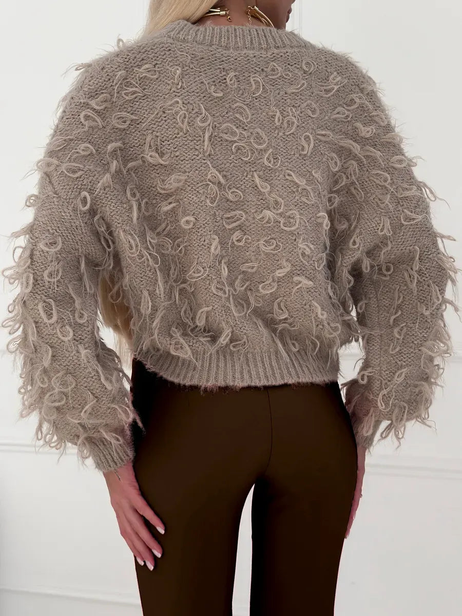 Sahara Cardigan by Lauven, cropped oversized beige bouclé knit with playful feathered fringe, back view.