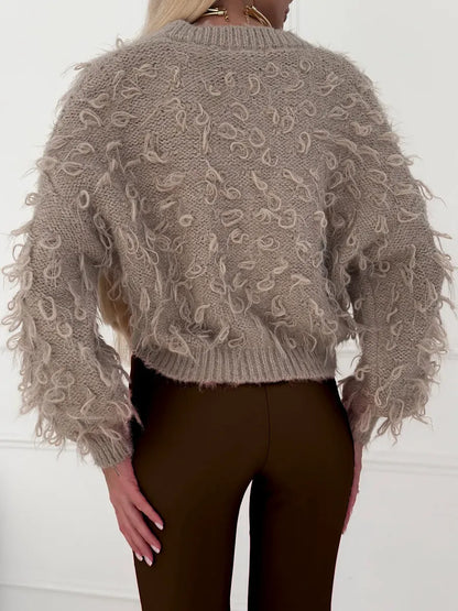 Sahara Cardigan by Lauven, cropped oversized beige bouclé knit with playful feathered fringe, back view.