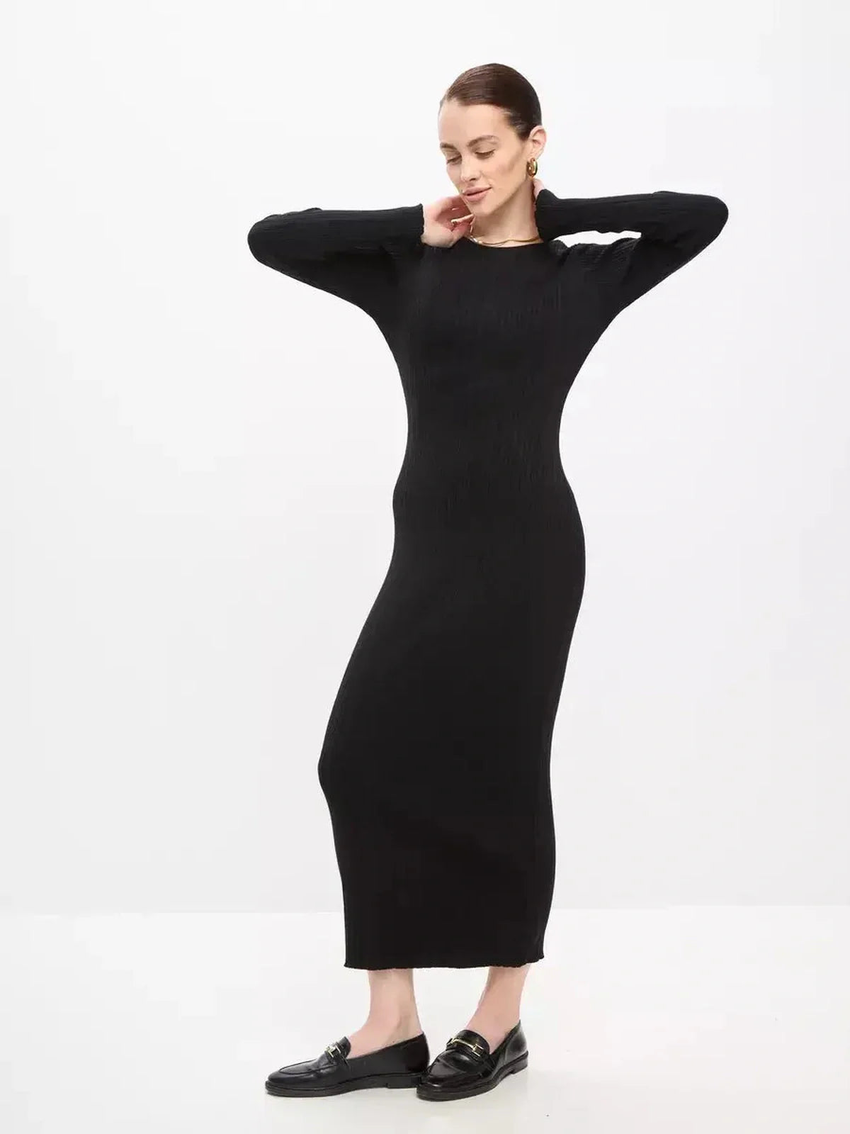 Model showcasing Sculpted Rib Maxi Dress in black, featuring a streamlined silhouette and long sleeves for elegant style.