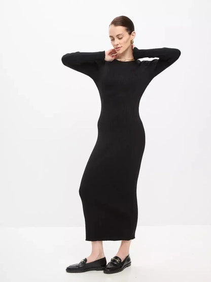 Model showcasing Sculpted Rib Maxi Dress in black, featuring a streamlined silhouette and long sleeves for elegant style.