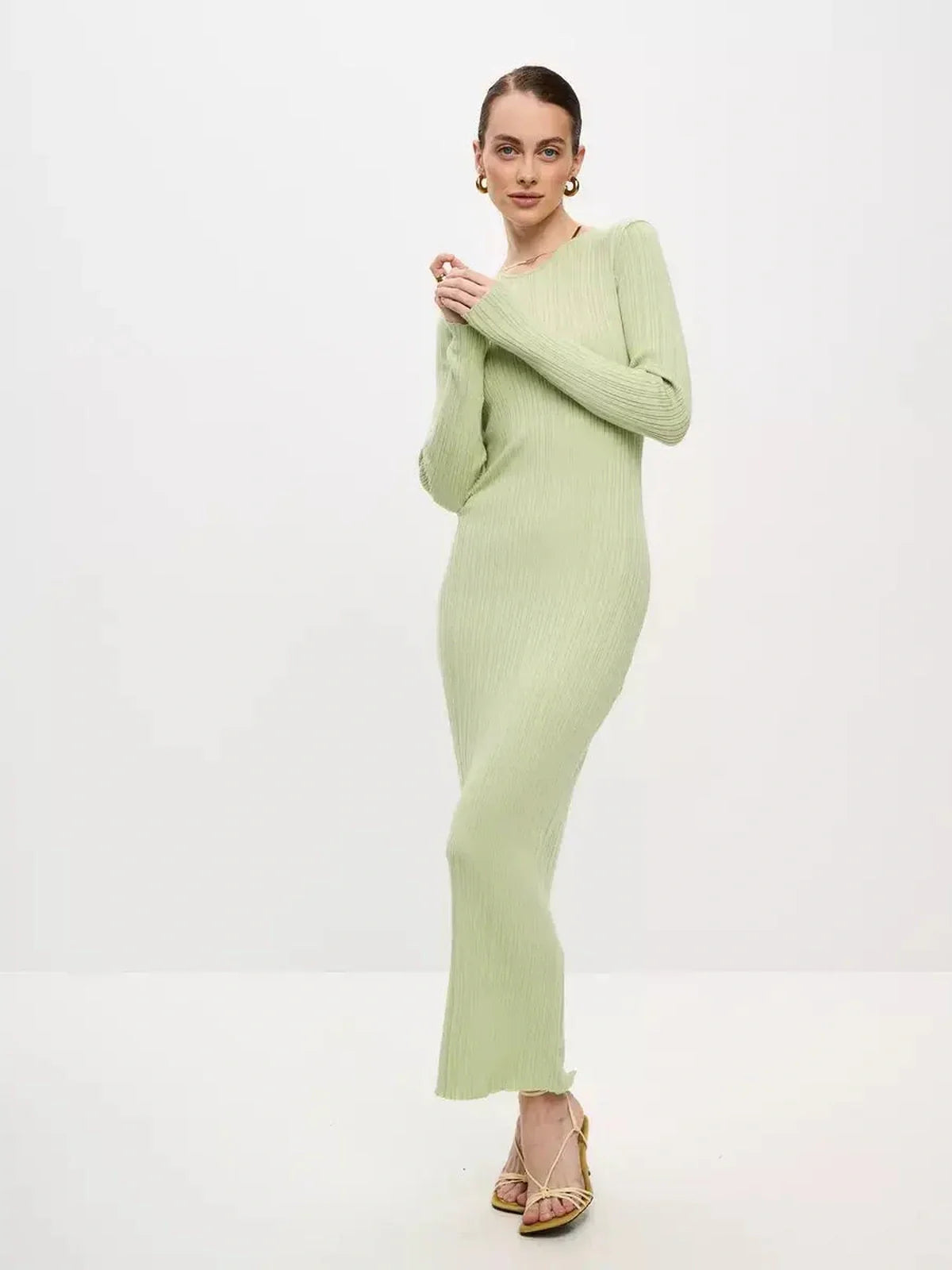 Model wearing the Celery Luxe Maxi Dress, a light green ribbed knit dress showcasing seamless elegance and sculpted fit.