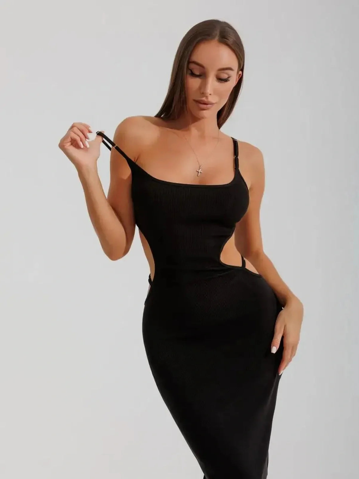 Model wearing the Midnight Silhouette Midi Dress featuring curve-hugging cutouts and a sculpted fit in black fabric.
