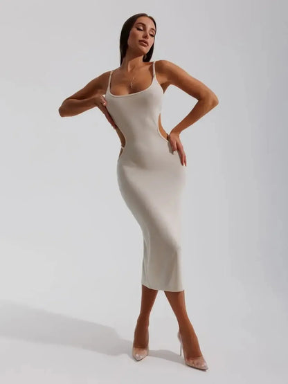 Elegant beige midi dress with sculpted side cutouts, showcasing a body-hugging silhouette and spaghetti straps.