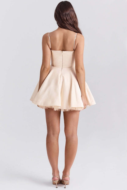 Back view of a Inez Mini Dress in soft beige, featuring a fluffy skirt ideal for summer weddings and special occasions.