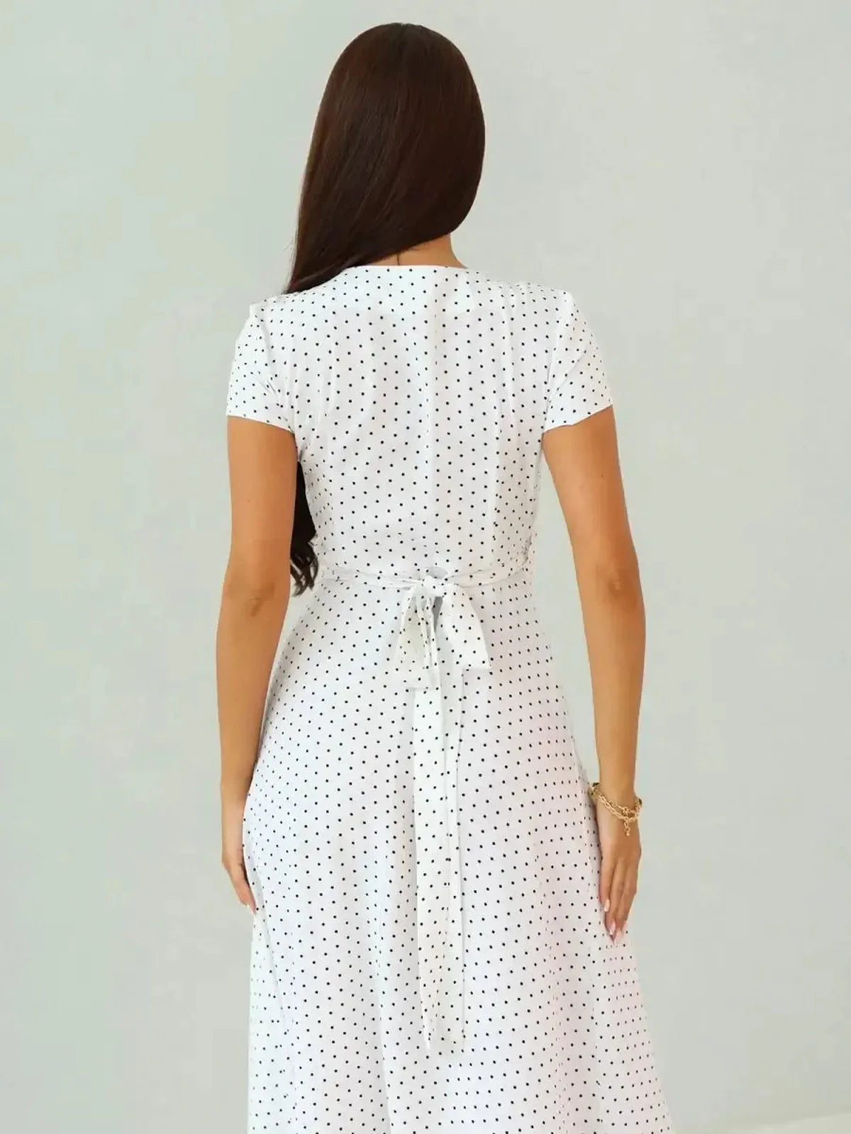 Back view of the Ivory Dots Maxi Dress showcasing its wrap-style silhouette and polka dot pattern.