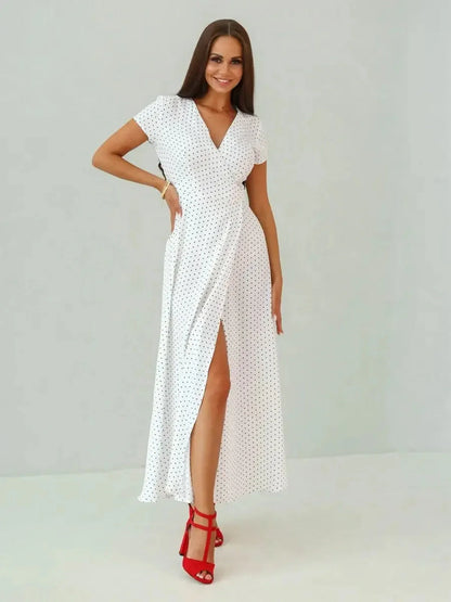Ivory Dots Maxi Dress featuring a wrap silhouette, short sleeves, and high slit, styled with red heels.