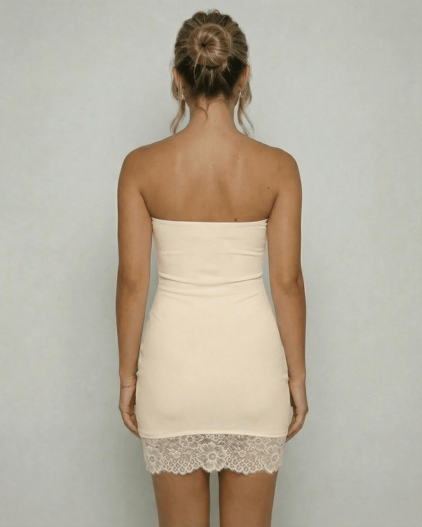 Ivorya Mini Dress by Lauven, showing the back view of a strapless ivory sheath dress with lace hem detail.