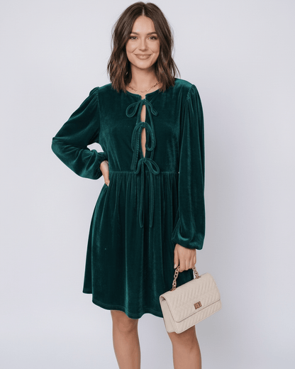 Elegant model wearing a Jade Mini Dress by Lauven, featuring velvet fabric, lantern sleeves, and a drawstring front.