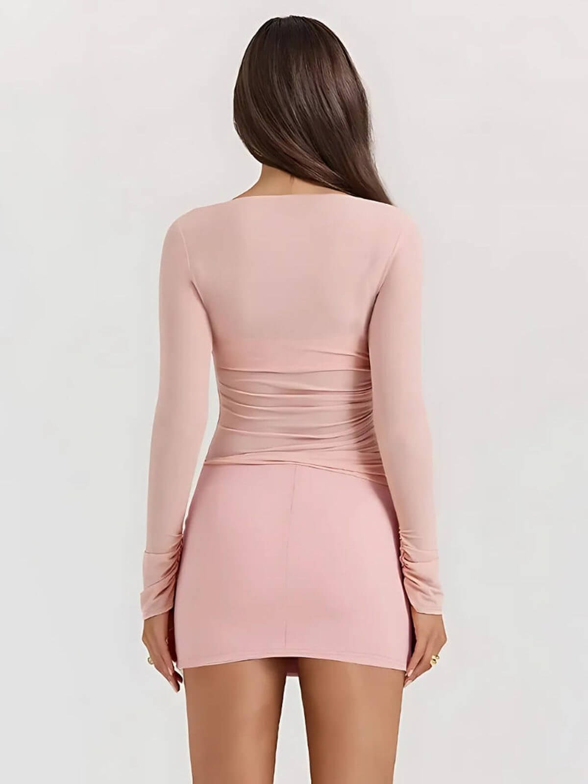 Rear view of the Juno Mini Dress in soft pink, showcasing its long sleeves and figure-hugging silhouette.
