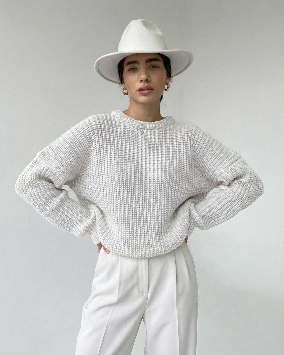 Alba Sweater by Lauven, textured knit with a modern silhouette, styled with white trousers and a wide-brim hat.