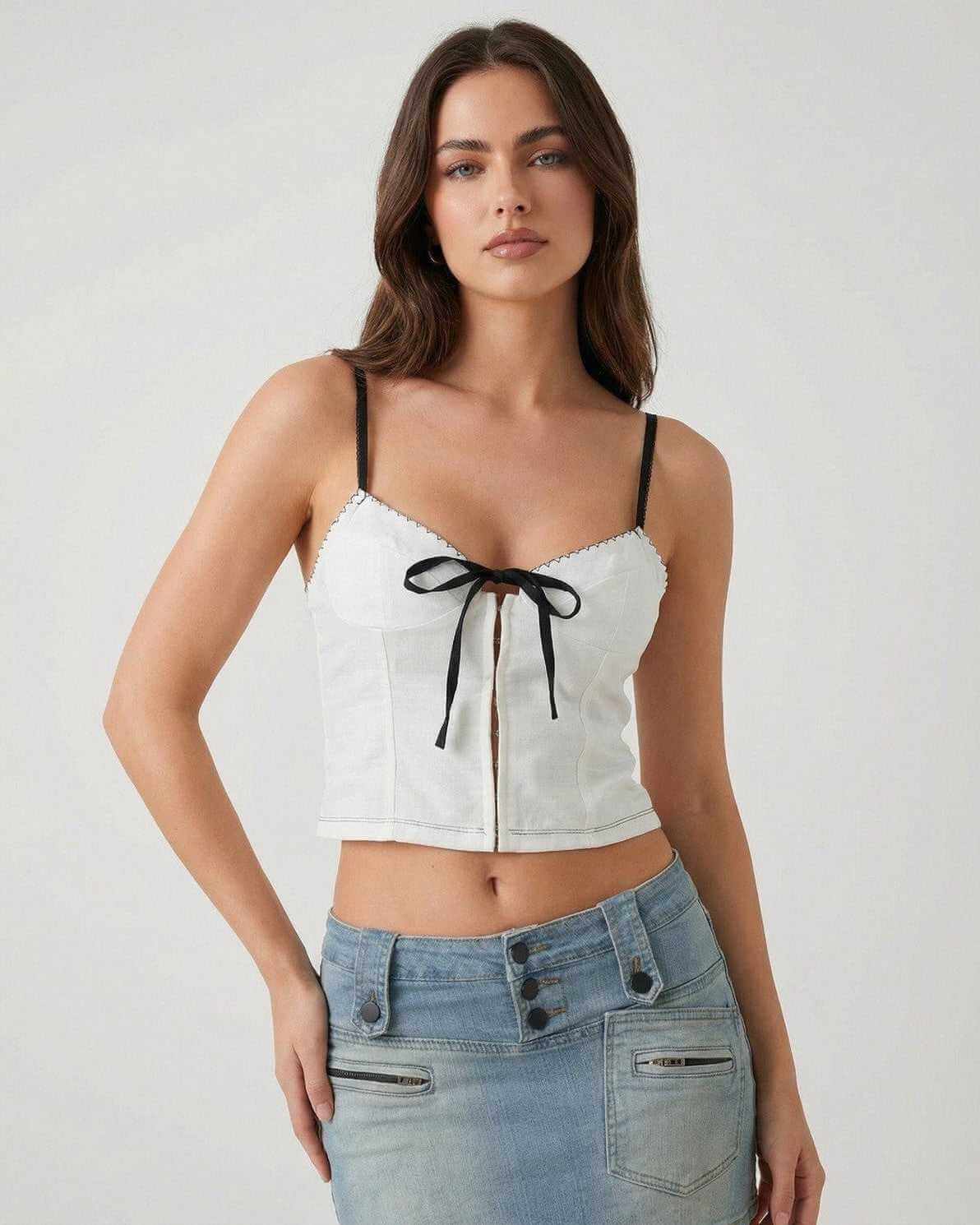 Arden Top by Lauven – White camisole with black bow detail, featuring delicate straps and a stylish silhouette.