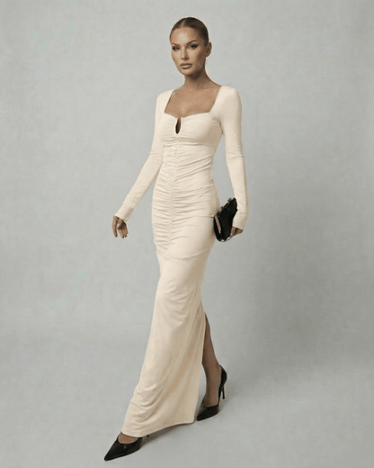 A model wearing the Lauven Astra Maxi Dress, a long sleeve square neck beige maxi dress with high-waist design.