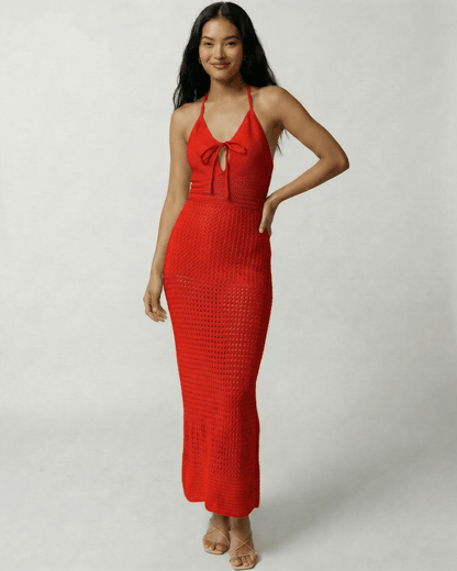 Model wearing the Aurelia Maxi Dress by Lauven, a red crochet halter maxi dress with an open back.