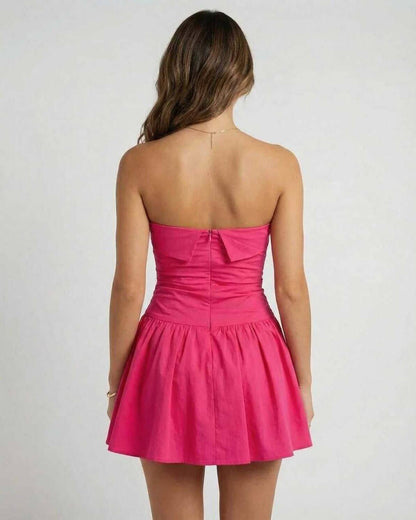 Back view of Azalea Mini Dress by Lauven in vibrant pink, featuring a strapless A-line silhouette and flared skirt.