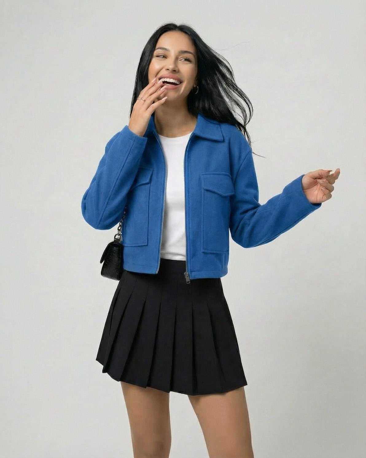 Woman wearing Azure Jacket by Lauven, a stylish blue jacket with a polo collar, paired with a black skirt.