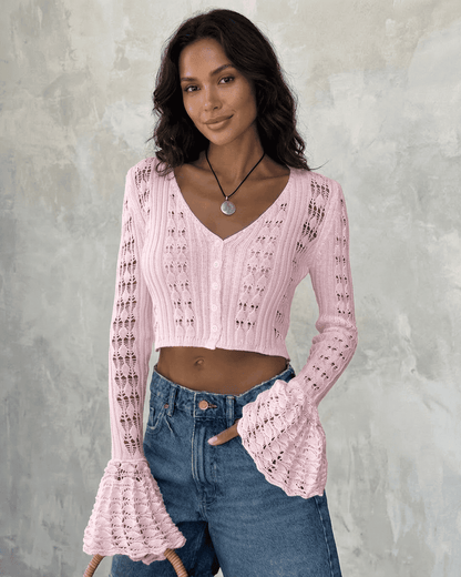 Model wearing a Blossom Cardigan by Lauven, cropped pink knit with flare sleeves and V-neckline.