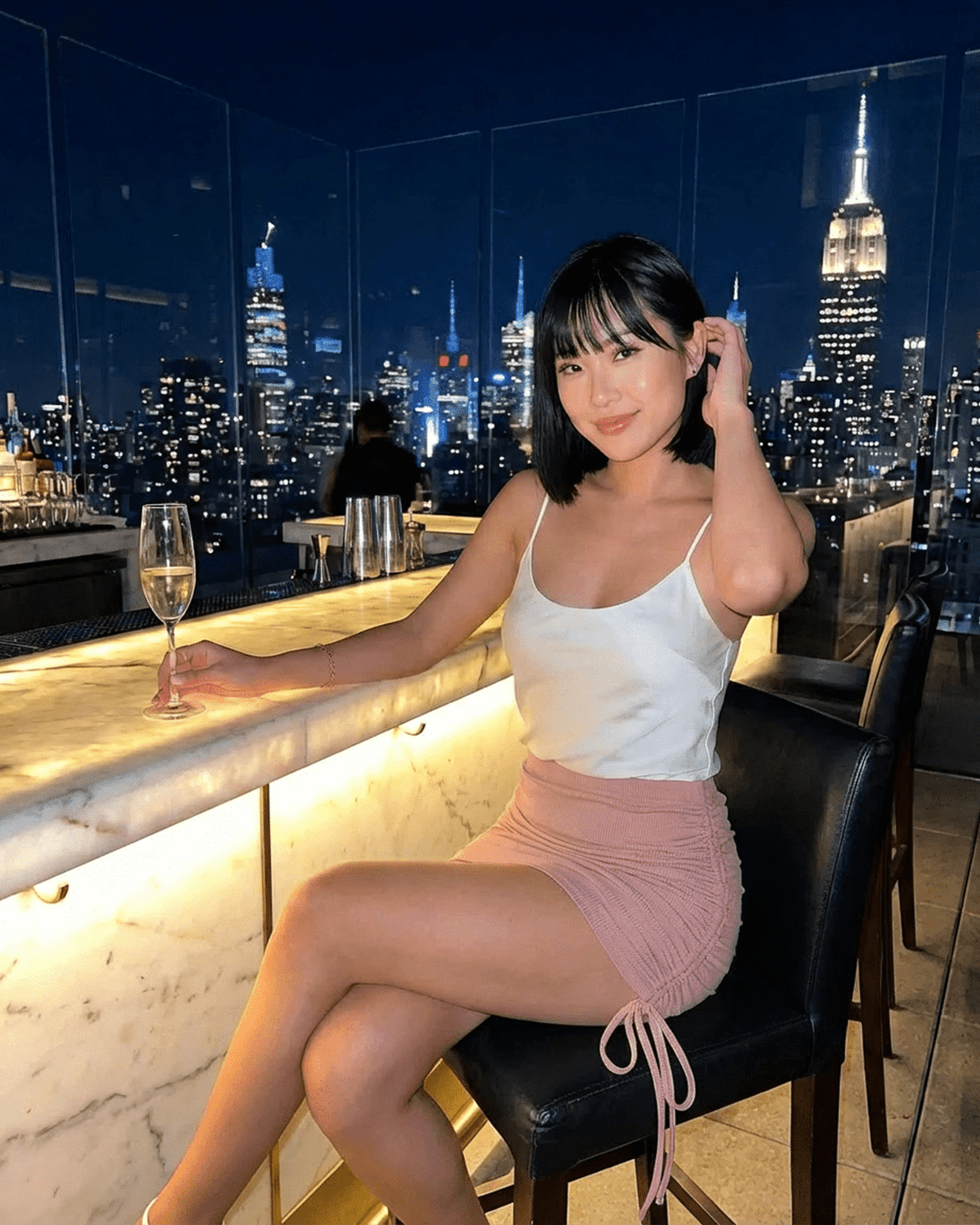 Blush Mini Skirt by Lauven, high-waisted bodycon style showcased in an elegant setting with city skyline background.
