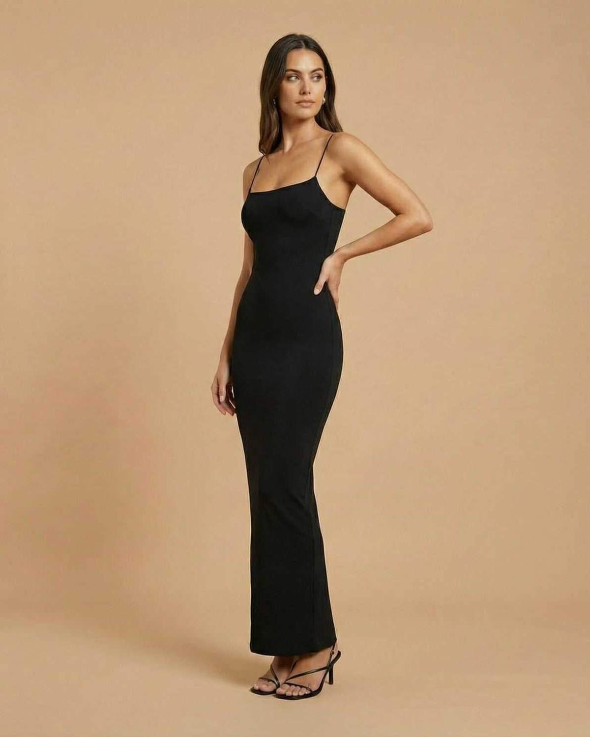 Calypso Maxi Dress by Lauven, featuring a sleek black backless silhouette with spaghetti straps and elongated length.