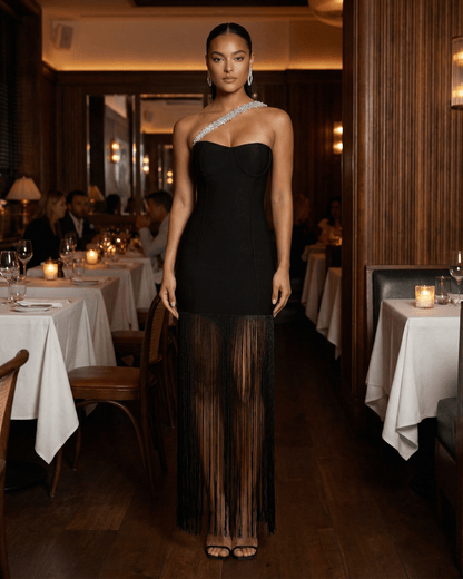 Celestia Maxi Dress by Lauven, black one-shoulder sheath with fringe detail in an elegant dining setting.