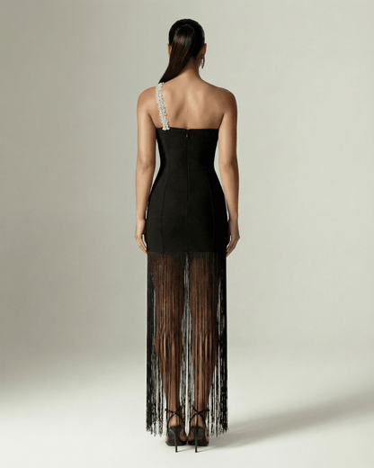 Back view of the Celestia Maxi Dress from Lauven, featuring a black one-shoulder design and elegant fringed hem.