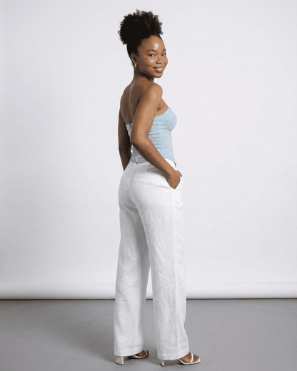 Denali Corset Top by Lauven, showcasing a woman in a faux denim bustier with stylish white linen pants.
