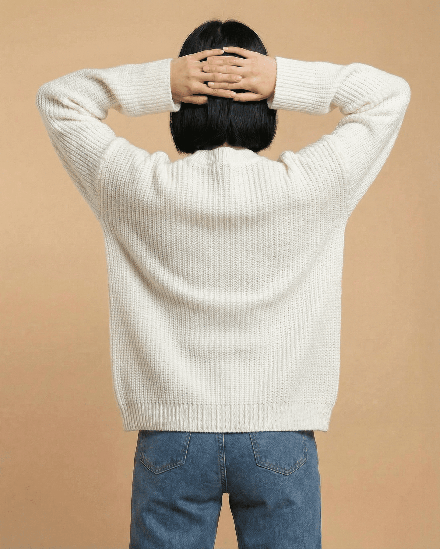 Back view of a woman wearing the Elara Cardigan by Lauven, showcasing its loose fit and knit texture.