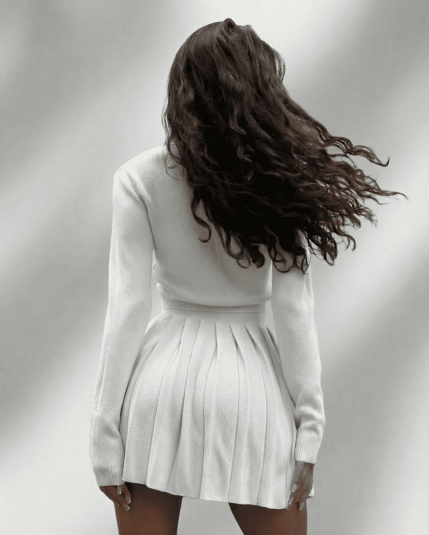 Elara Two-Piece Set featuring knit cardigan and pleated mini skirt from Lauven, showcasing a modern feminine silhouette.