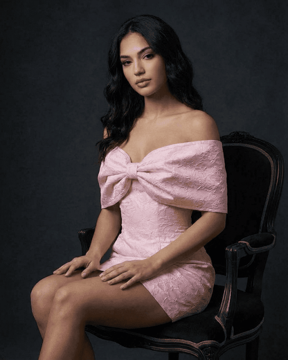 Fiora Mini Dress by Lauven showcases a stunning off-the-shoulder neckline with a bowknot detail in soft pink.