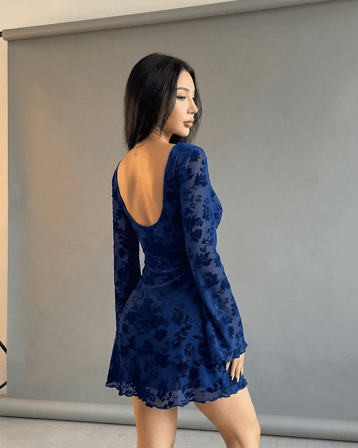 Fleur Mini Blue by Lauven, featuring a back view of a model in a floral cutout long sleeve bodycon dress.
