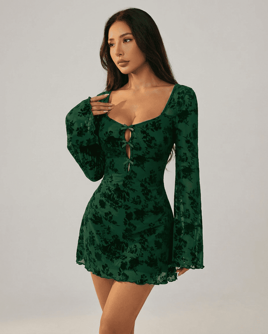 Fleur Mini Green dress by Lauven featuring flocked floral cutouts and long flared sleeves on a model.
