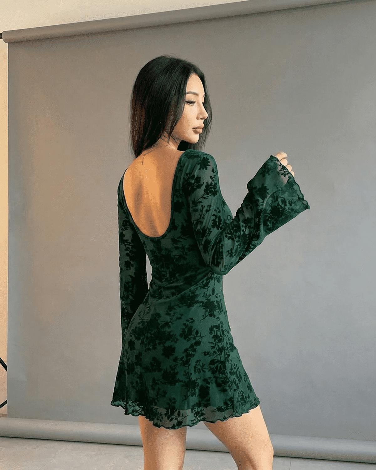 Fleur Mini Green by Lauven - Model showcasing back view of floral cutout bow long sleeve bodycon mini dress in green.