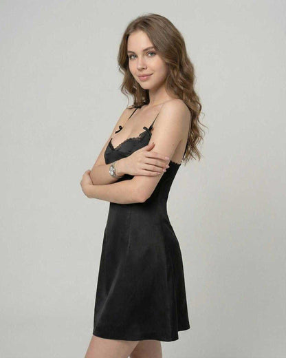 Florence Mini Dress by Lauven showcasing a sleek satin slip silhouette and ruffle trim against a neutral background.