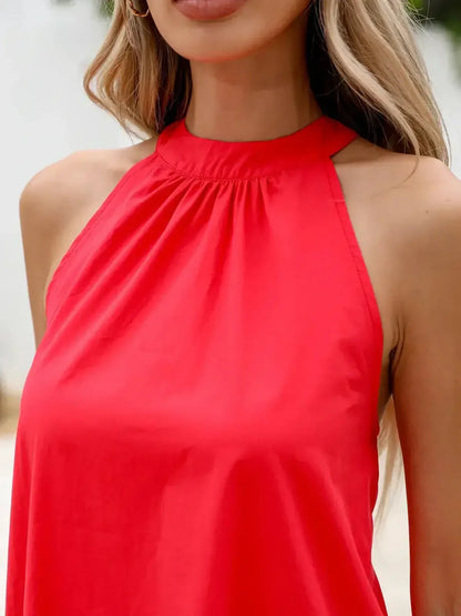 Close-up of a woman's halter neck in a vibrant fuchsia mini dress with a ruched collar.