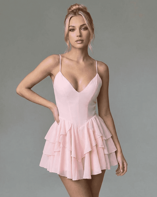 Model wearing Isolde Mini Dress by Lauven, a pink ruffle party mini dress with a V-neck and spaghetti straps.