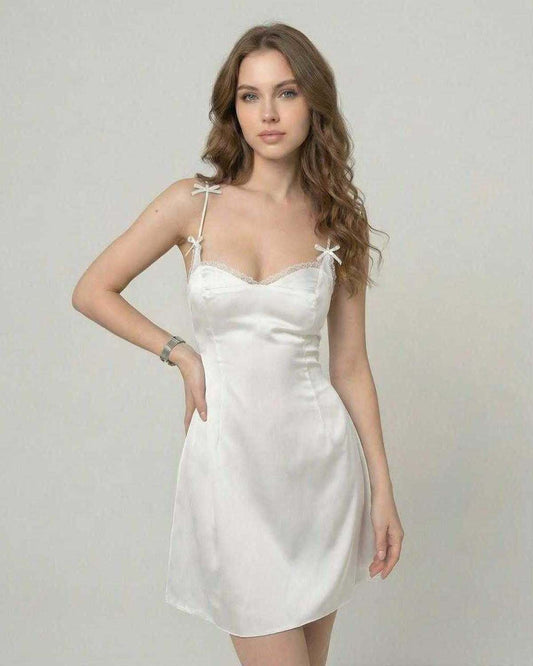 Ivory Mini Dress by Lauven featuring a satin slip silhouette, ruffle trim, and a delicate neckline with spaghetti straps.