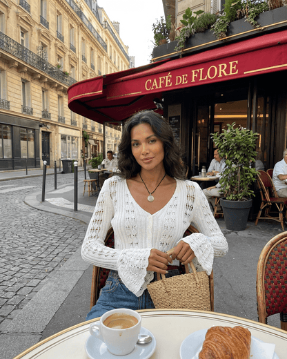 Lauven Laceflare Cardigan worn outdoors at Café de Flore with coffee and pastry, featuring lace details and flare sleeves.