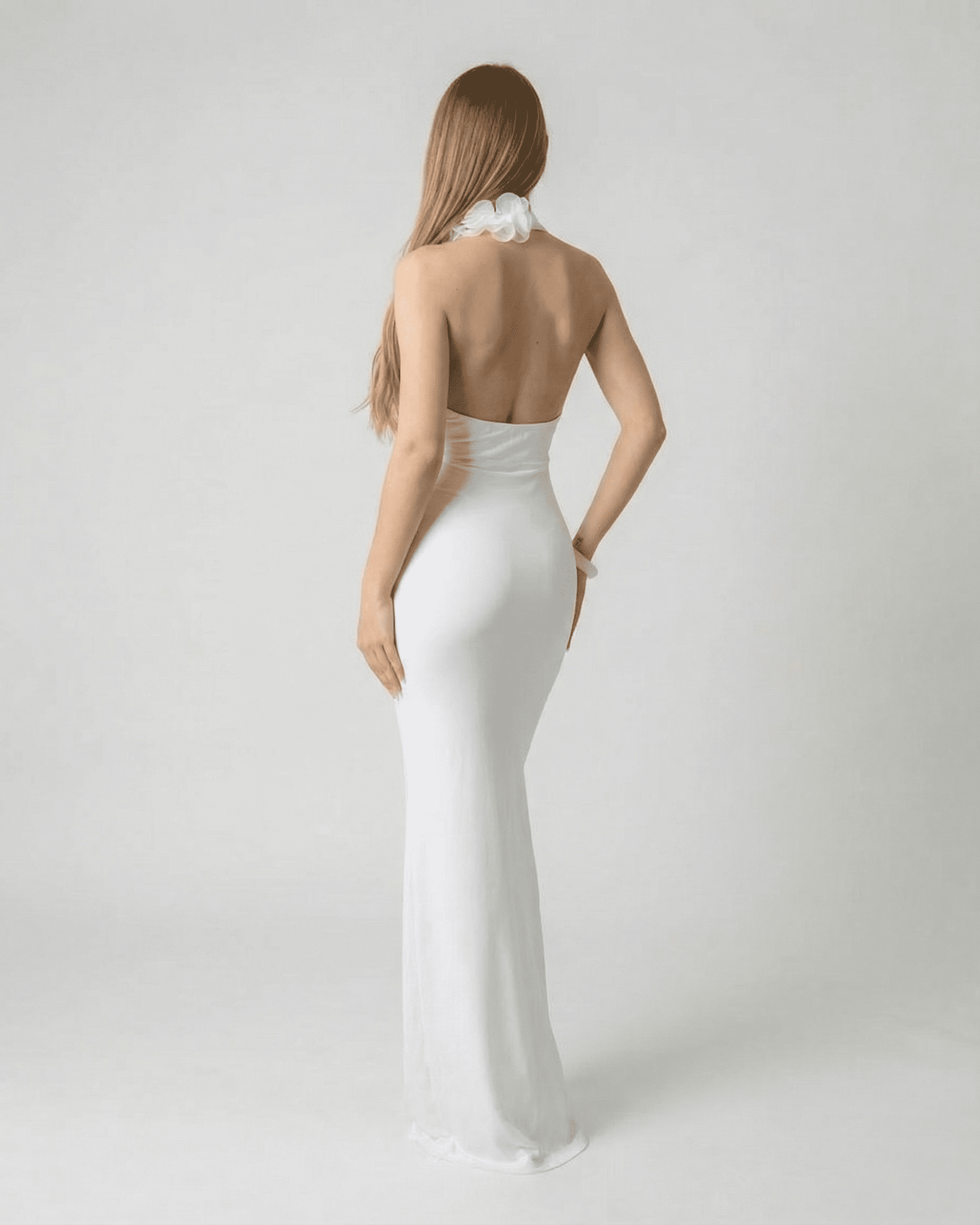 Lumière Maxi Dress by Lauven - Back view of a white deep V neck backless maxi dress with 3D floral detail.