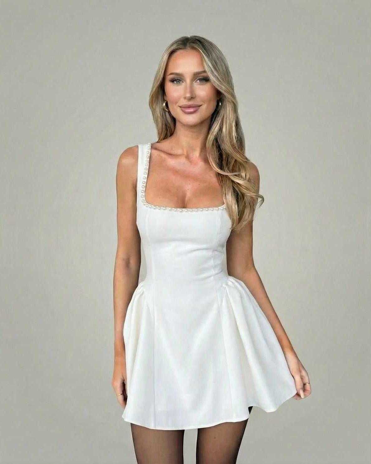 Model wearing the Lauven Luna Mini Dress featuring a pearl-trim square neckline and A-line silhouette in white.