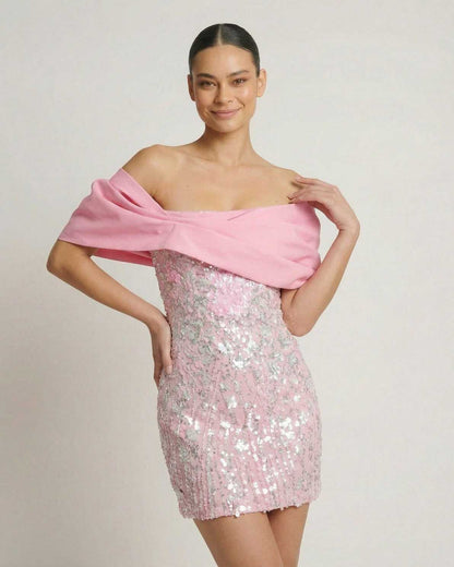 Lauven Luna Mini Dress in pink sequins with off-the-shoulder draped chest wrap, perfect for parties.