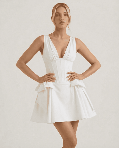 Model wearing the Luna Mini Dress by Lauven, a white V-neck corset pouf mini dress with playful volume.