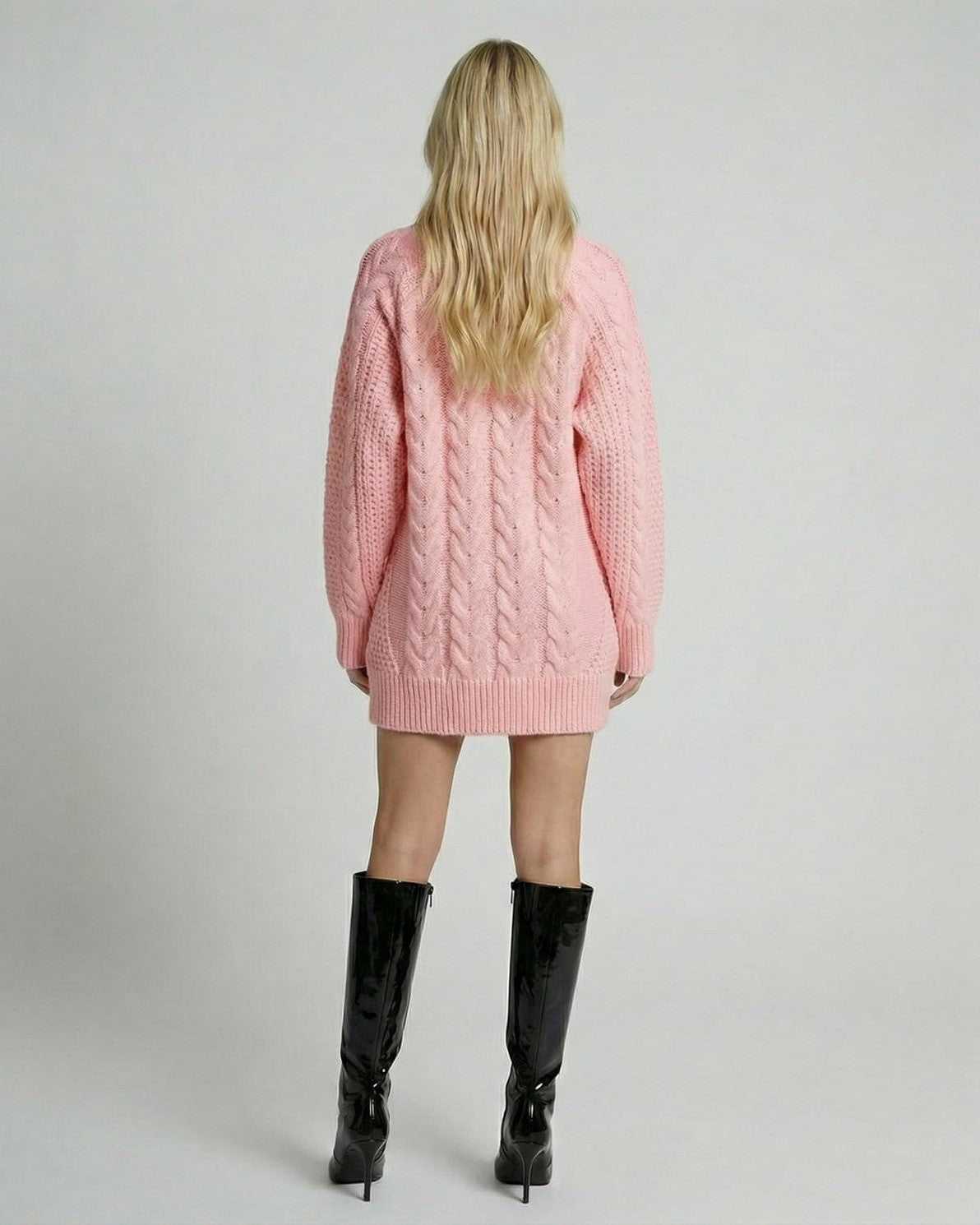 Back view of a model wearing the soft pink Luna Sweater by Lauven, showcasing its stylish cable-knit design.