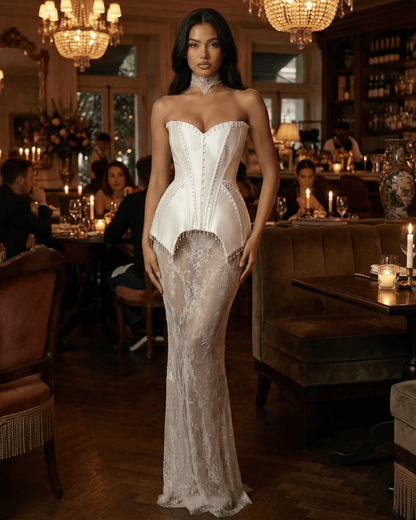 Lunaria Maxi Dress by Lauven, featuring a strapless corset bodice and sheer lace skirt in an elegant restaurant setting.