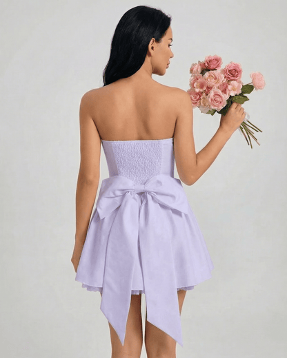Lunaria Mini Dress by Lauven features a strapless design with a high-waist silhouette and a bow detail in soft lavender.