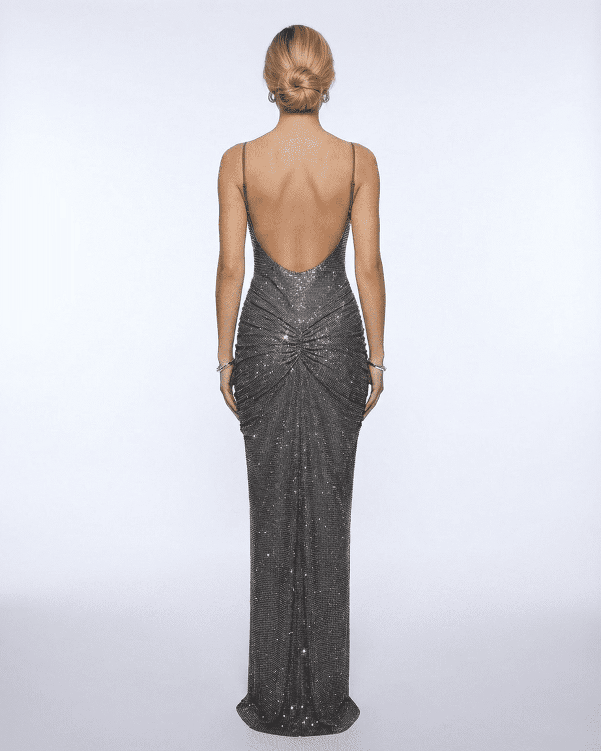 Back view of a woman wearing the Lyra Maxi Dress from Lauven, showcasing its metallic crystal embellishments and elegant silhouette.